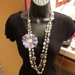 Long necklace with clear beads and a flower